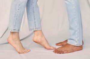 Two people showing their bare feet with one having flat arches