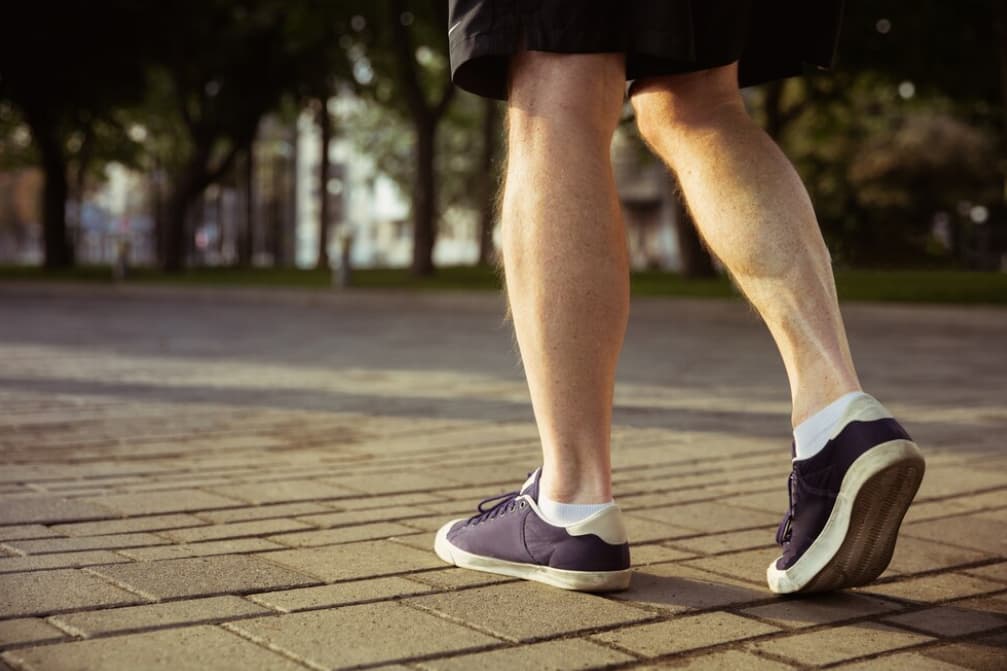 Walking in sneakers, the focus is on the legs and feet