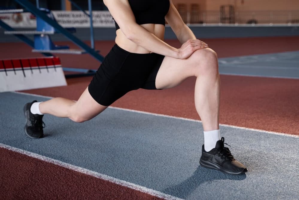 An athlete stretching on a running track